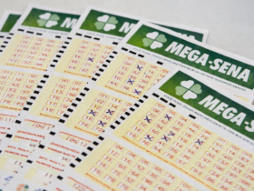 Vários volantes da Mega-Sena dispostos sobre superfície clara, com números marcados em caneta azul para participação no sorteio