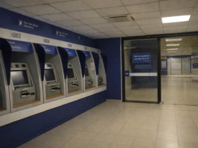 Pessoas realizando saques e depósitos em caixas eletrônicos dentro de agência bancária no Brasil