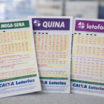 Volantes da Mega-Sena, Quina e Lotofácil sobre balcão com fundo desfocado, representando rodada tripla de sorteios da Caixa