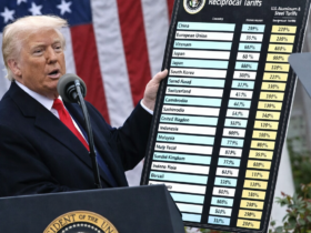 Autoridade norte-americana apresenta painel com tarifas sobre aço e alumínio diante da bandeira dos Estados Unidos, simbolizando política comercial dos EUA