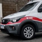 Viatura da Polícia Militar de São Paulo estacionada em área urbana, com faixa vermelha e número 190 visíveis na lateral