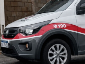 Viatura da Polícia Militar de São Paulo estacionada em área urbana, com faixa vermelha e número 190 visíveis na lateral