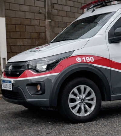 Viatura da Polícia Militar de São Paulo estacionada em área urbana, com faixa vermelha e número 190 visíveis na lateral