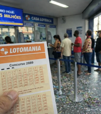 Cliente segura volante da Lotomania concurso 2889 em fila de casa lotérica com painel indicando prêmio de R$ 3,5 milhões.