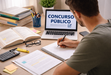 pessoa estudando para concurso público com materiais e computador em mesa organizada